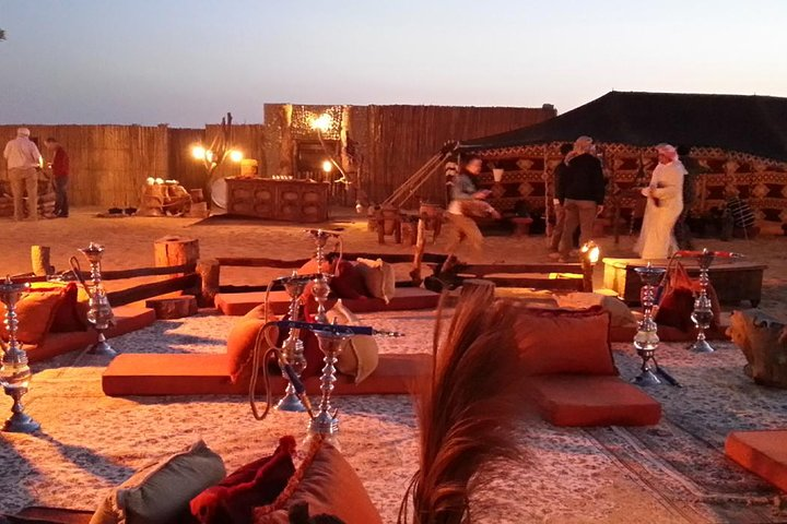 Relax on plush cushions as the sun dips below the dunes savoring Arabian coffee and dates. Enjoy a delightful evening with live entertainment in a captivating desert camp under the stars.